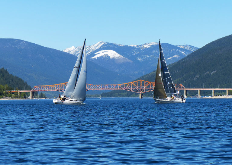 Two sailboat sailing towards Nelson's Big Orange Bridge